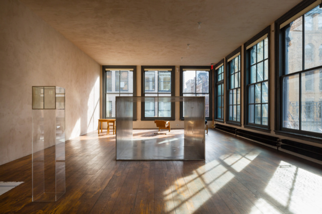 Interior of the Donald Judd Foundation home, a beige room framed by a square coffee table