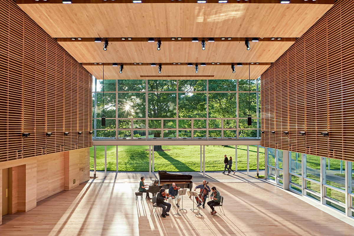 Image of sunlight streaming into wood-clad performance hall with retractable glass walls, Boston Symphony Orchestra quartet performing