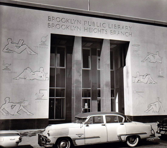 A black and white photo of WPA-esque bas reliefs on the front of a library