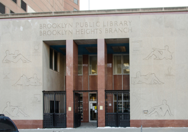 The Brooklyn Heights Library front entrance, featuring reclining people carved into limestone