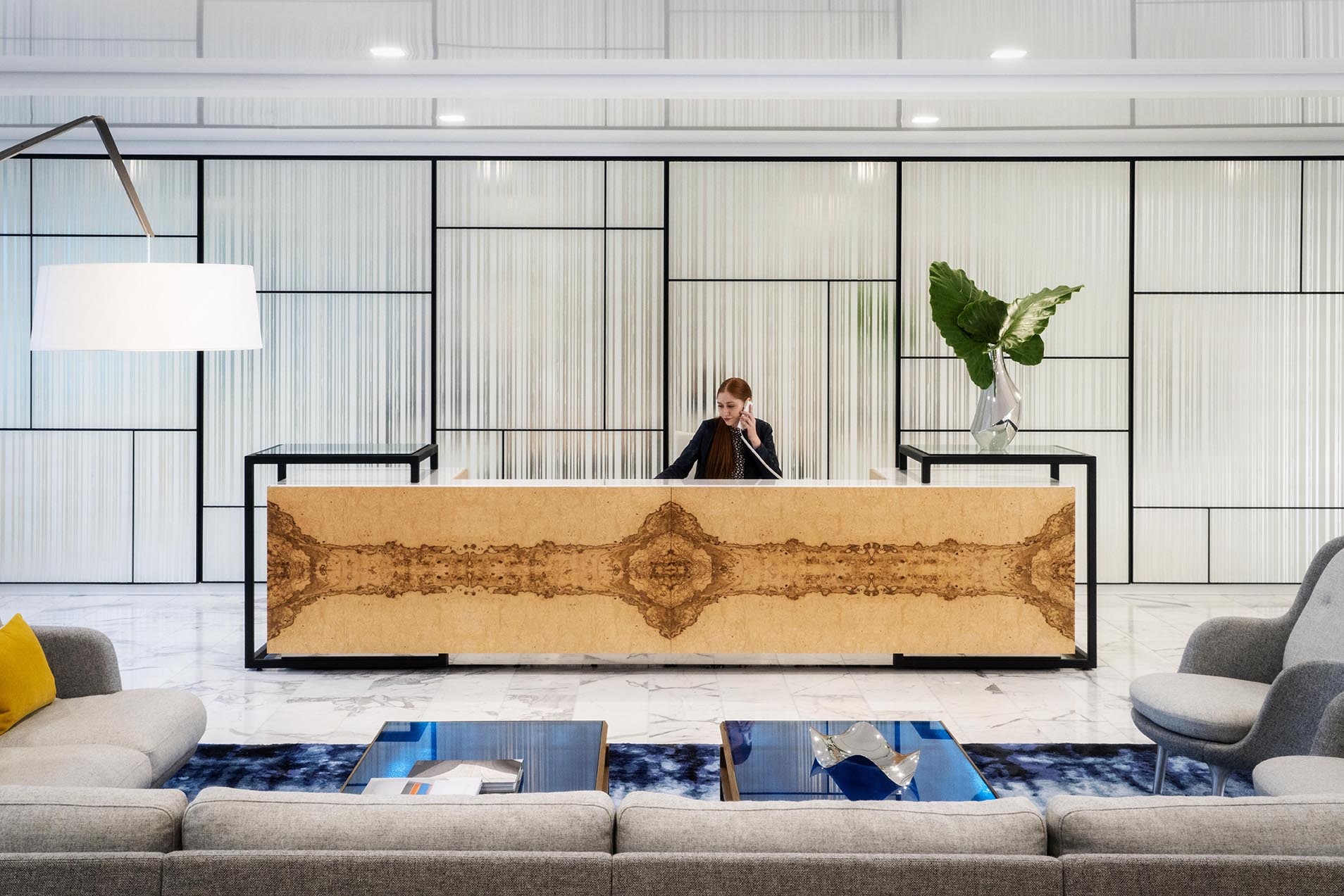 Photo of an office reception area with a wood desk and framed wakk