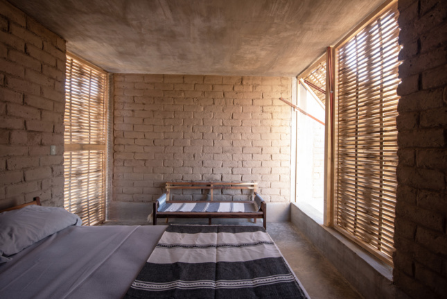 Interior view of bedroom with bench and bamboo lattice windows