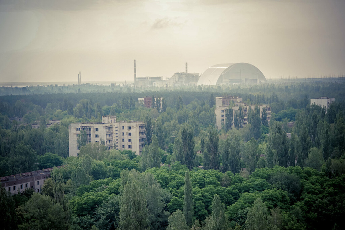 Image of treescape looking on to old nuclear plant, Chernobyl