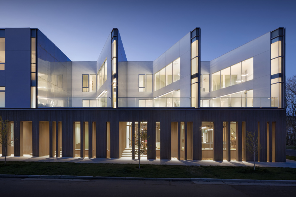 Exterior photo of Jason Street Multifamily, an undulating residential complex at night, designed by Meridian 105