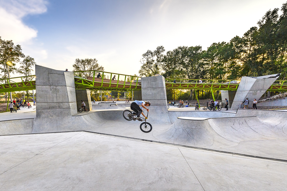 Photo in concrete bike bowl with twisting green-steeled bridge cutting through the Rock Star Energy Bike Park