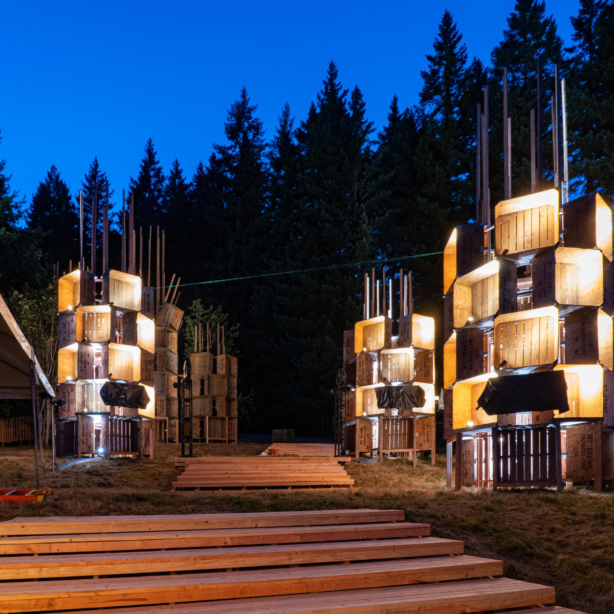 Photo of towers at night made from wooden apple bins, on the PSU campus for the Pickathon Music Festival