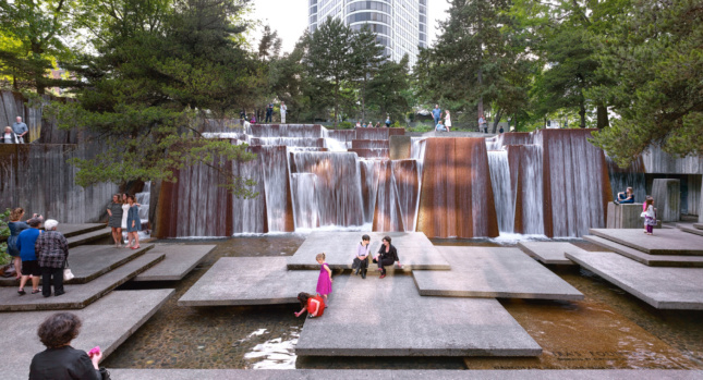 Image of children playing in large urban fountain with square landings and waterfall, from The Cultural Landscape Foundation