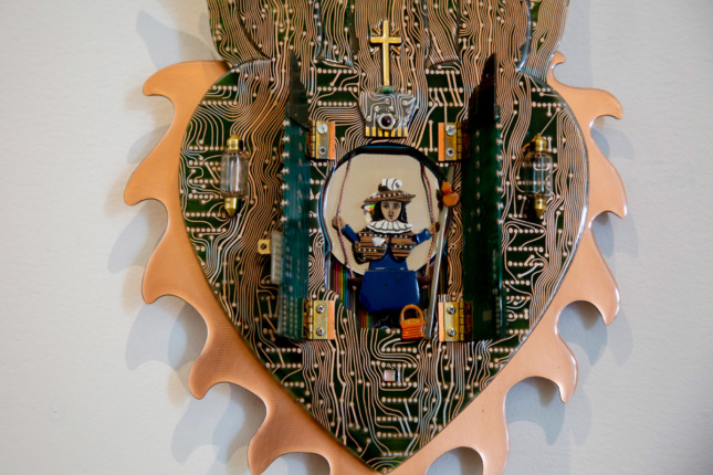 A heart with a saint in the center made from circuit boards