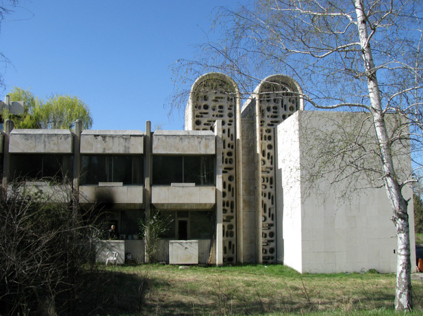 A concrete house with two silos in the center
