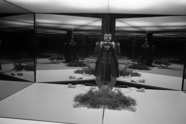 A black and white photo of a man, Cristiano Toraldo di Francia, in a mirrored room