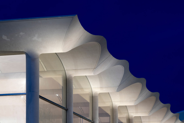 Close up night shot of white concrete arches on roof 
