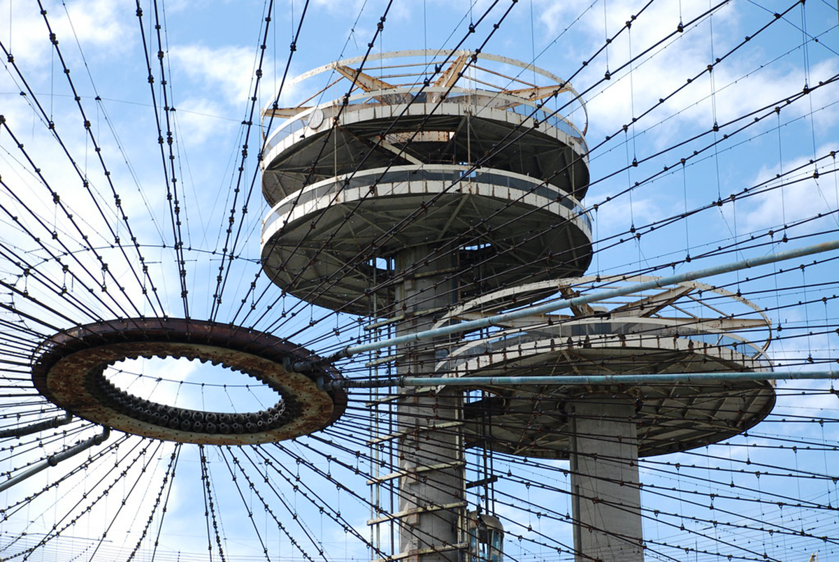 Close up image of concrete towers with observation platforms, seen through uncovered tent structure that makes up the New York State Pavilion