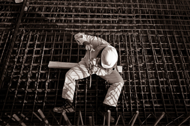 Aerial image of construction worker sitting on steel beams