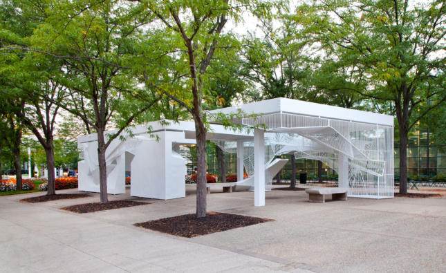 Installation view of a white metal pavilion with open bars