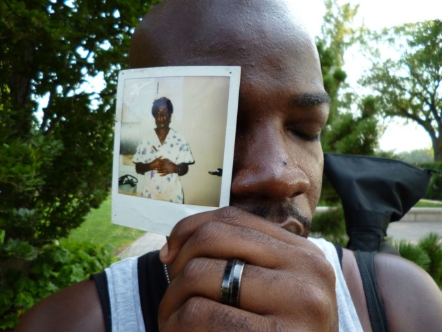 A man holding up a polaroid photo