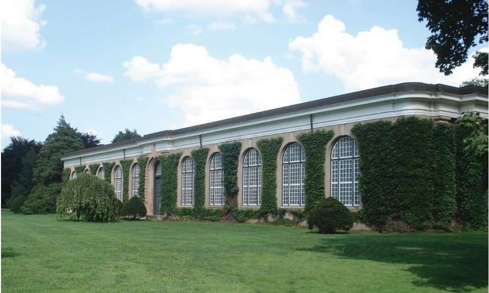 Exterior photo of the Orangerie, a historic brick building covered in ivy