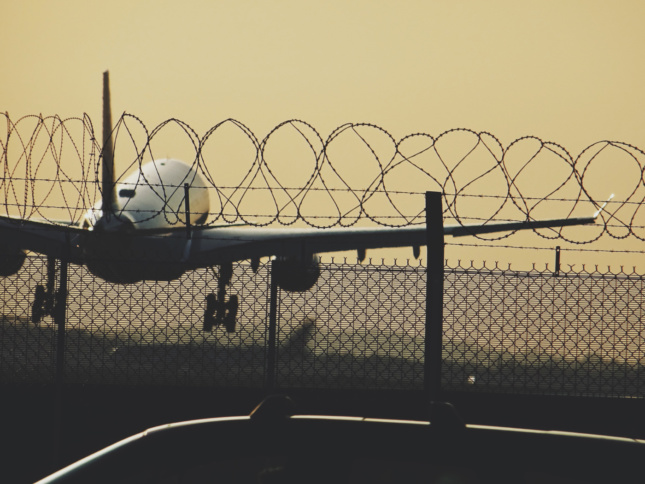 Photo of a plane taking off behind a fence at Heathrow Airport