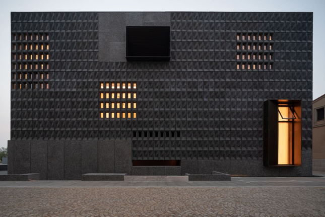 A darkened facade of triangular blocks