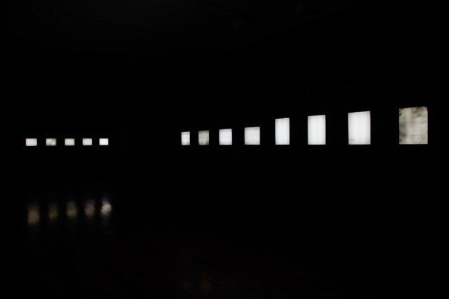 Image of exhibition space with backlit negatives. 
