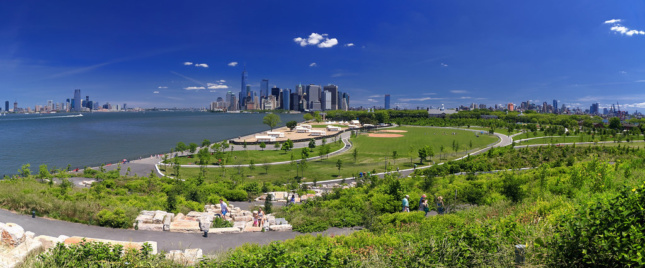 A park by the river with Manhattan in the background