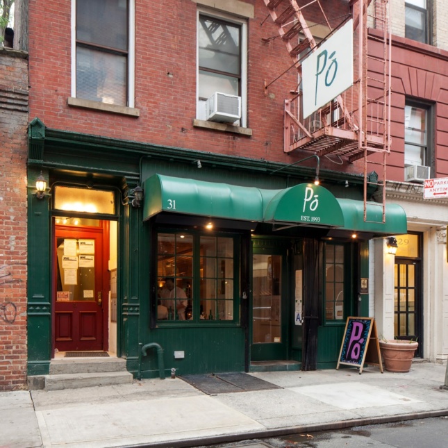 A photo of a small, green storefront attached to a brick building
