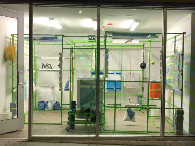A storefront gym made of green shelving rack