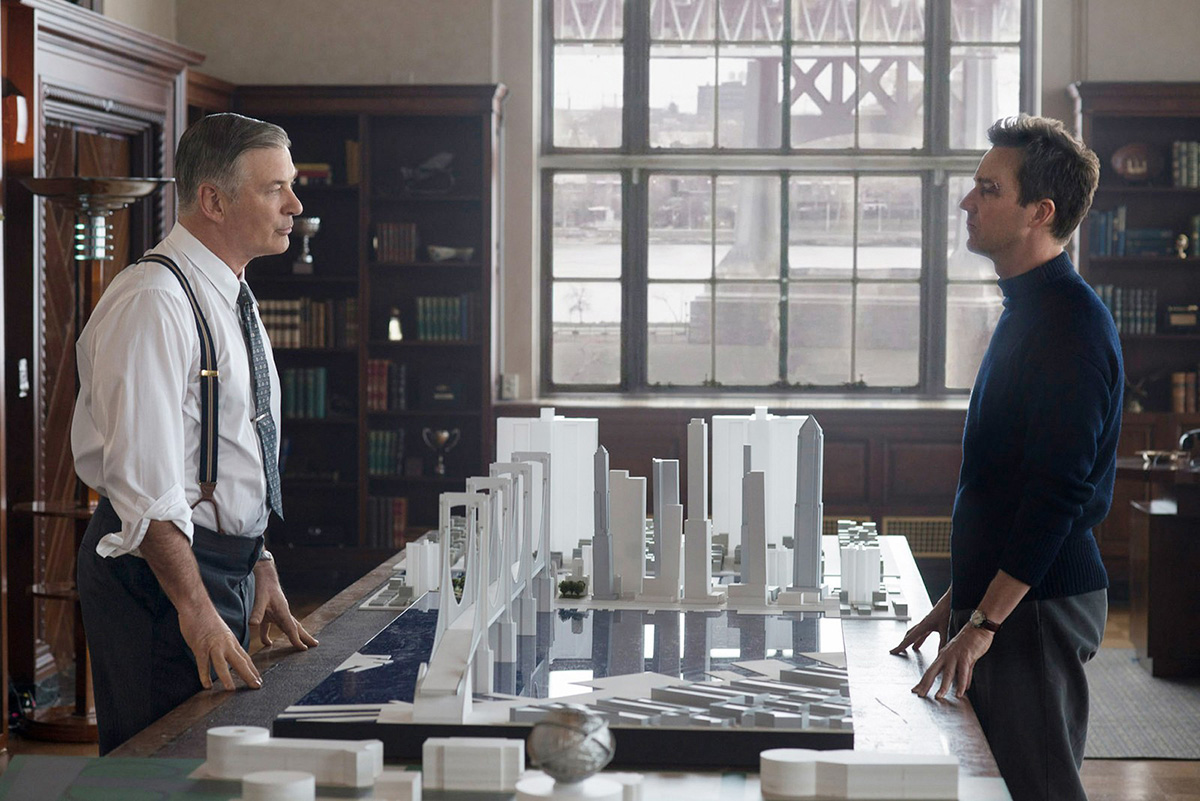 Image from Motherless Brooklyn film where Edward Norton and Alec Baldwin stare across a table with architectural models