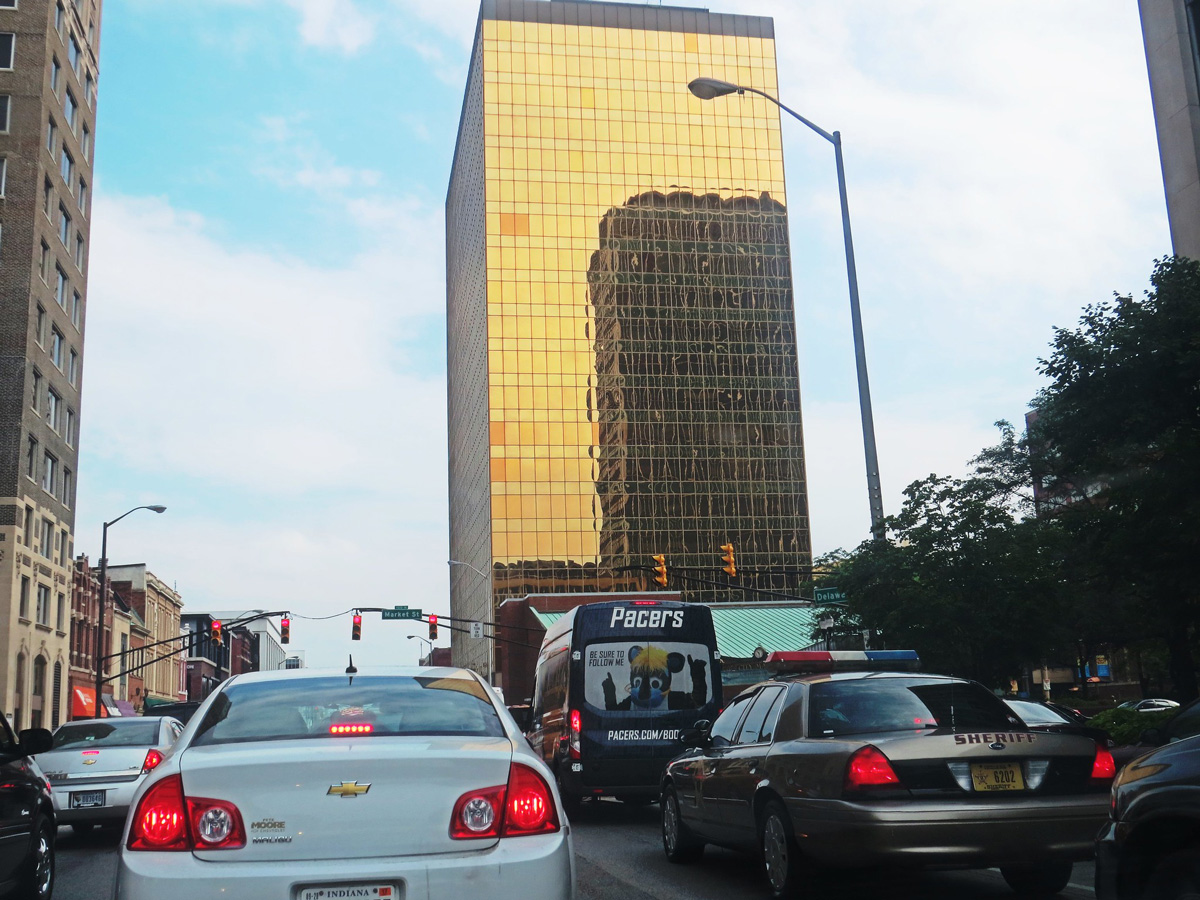 Traffic in front of gold-glass-wrapped building