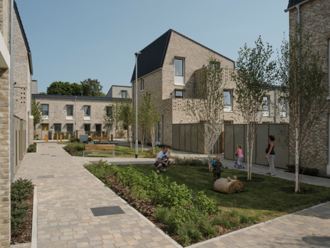 A communal green space behind brick homes