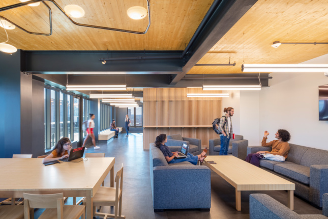 Students in a lounge with timber ceilings