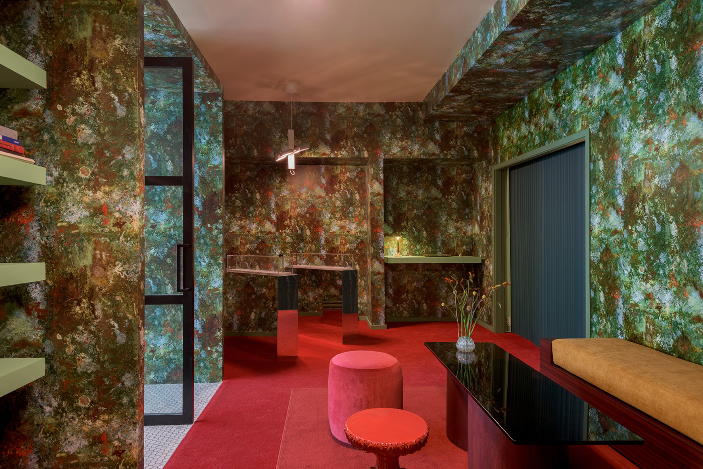 Interior of a retail space with a mottled green wallpaper