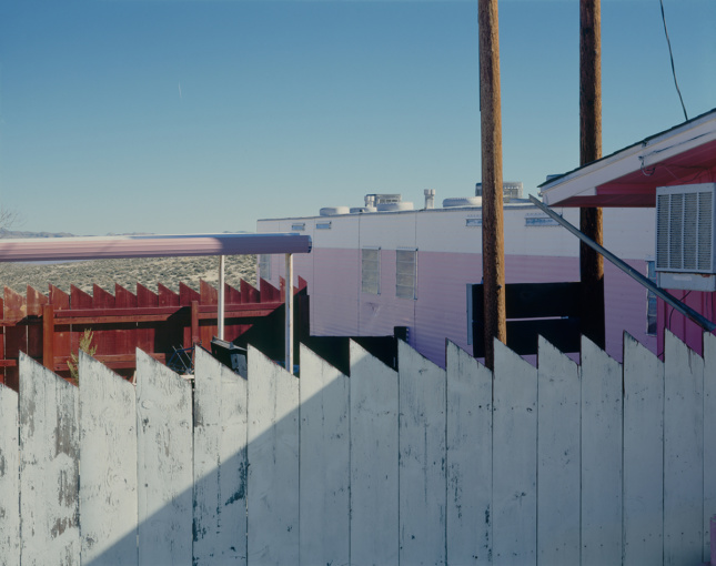 Fence of a brothel with pink and white walls 