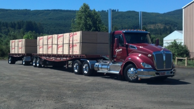 Image of truck carrying stacks of flat lumber panels