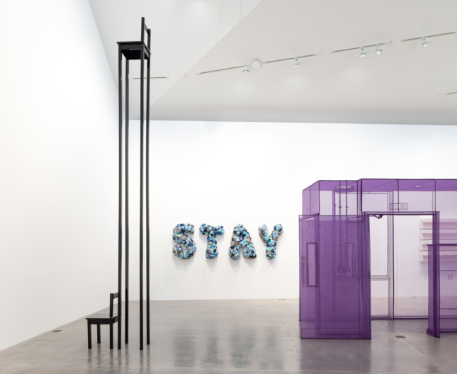 A 16-foot-tall chair next to a sign reading "STAY" in blue flowers