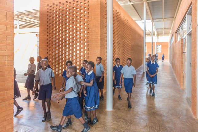Interior shot of school children walking through halls