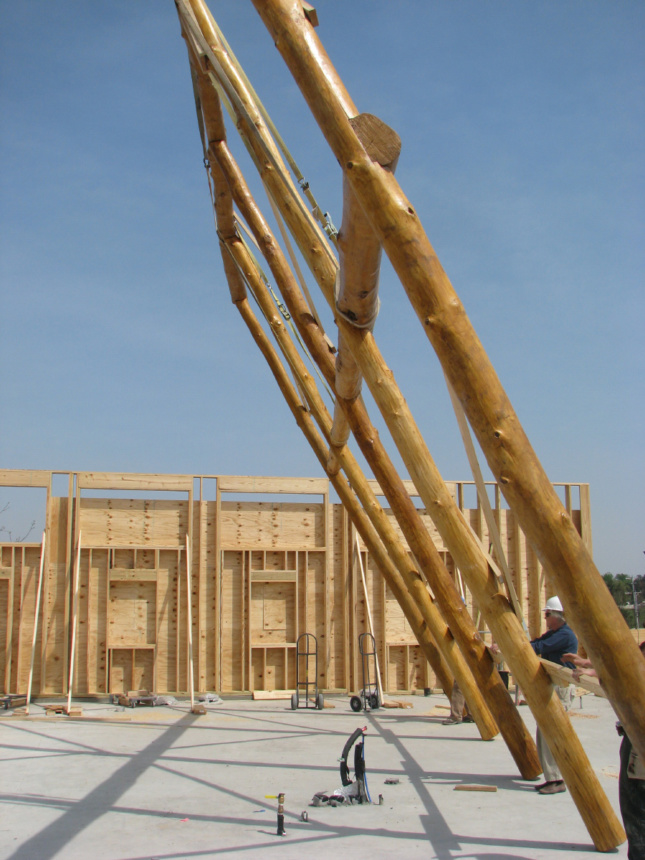 A large timber frame being raised into place