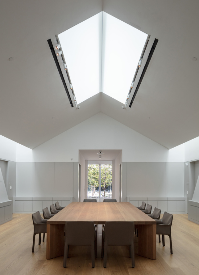 A conference room with a triangular skylight above the table