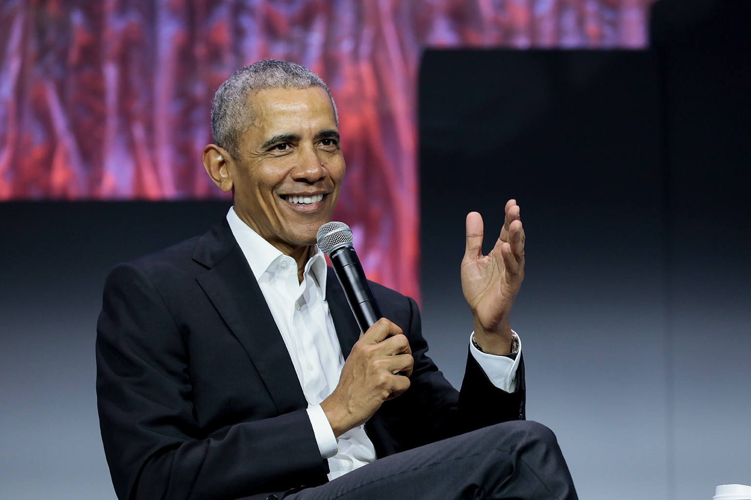 President obama sits holding a microphone giving a keynote talk at Greenbuild 2019