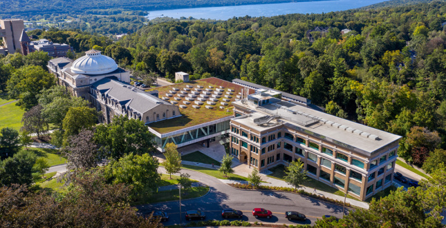Aerial view of buildings at Cornell next to trees and lake