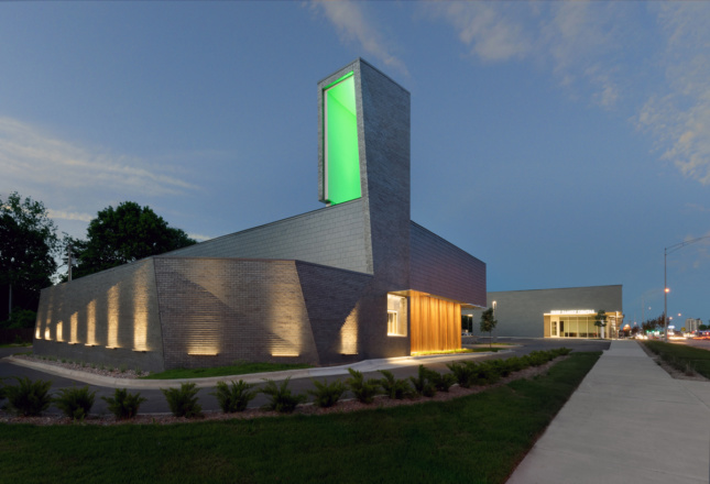 Exterior of a multifaceted stone building with a green light on top