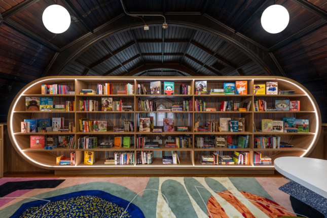 Round bookshelf filled with books on colorful carpet 