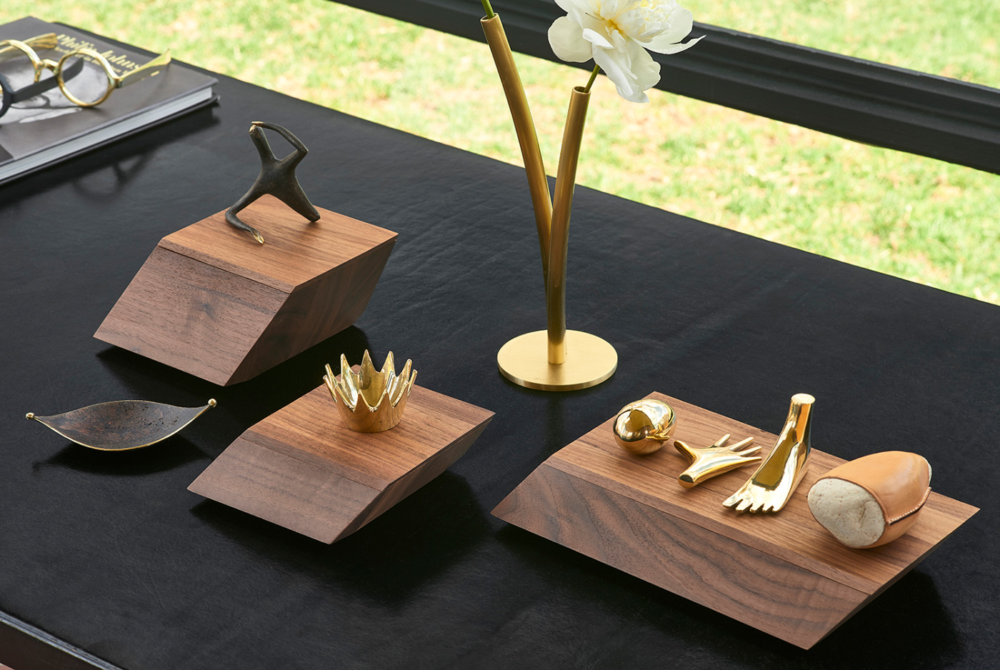 A selection of gold and brass keepsakes on top of walnut pedestals