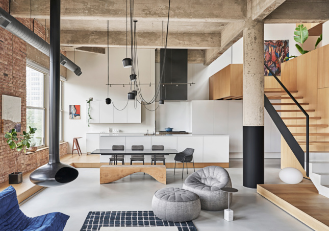 Loft interior with exposed concrete columns and a suspended fireplace