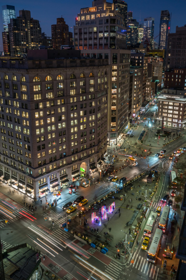 Aerial photo of the plaza in front of the Flatiron Building with lit-up pavilion