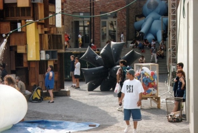 A crowd walking through an assortment of inflatables in a museum courtyard