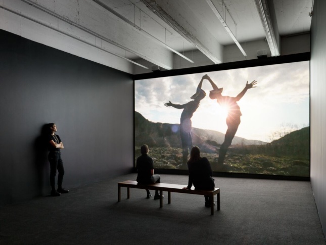 Installation view of a film with two masked dancers