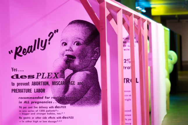 A pink wall text with a baby