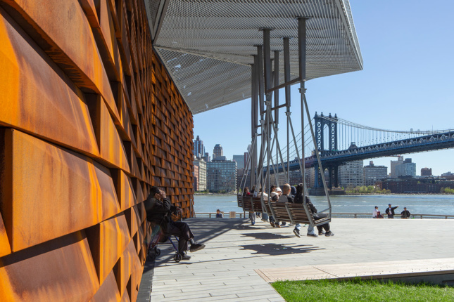 A detail view of a pier structure with additional views of the East River and Brooklyn Bridge