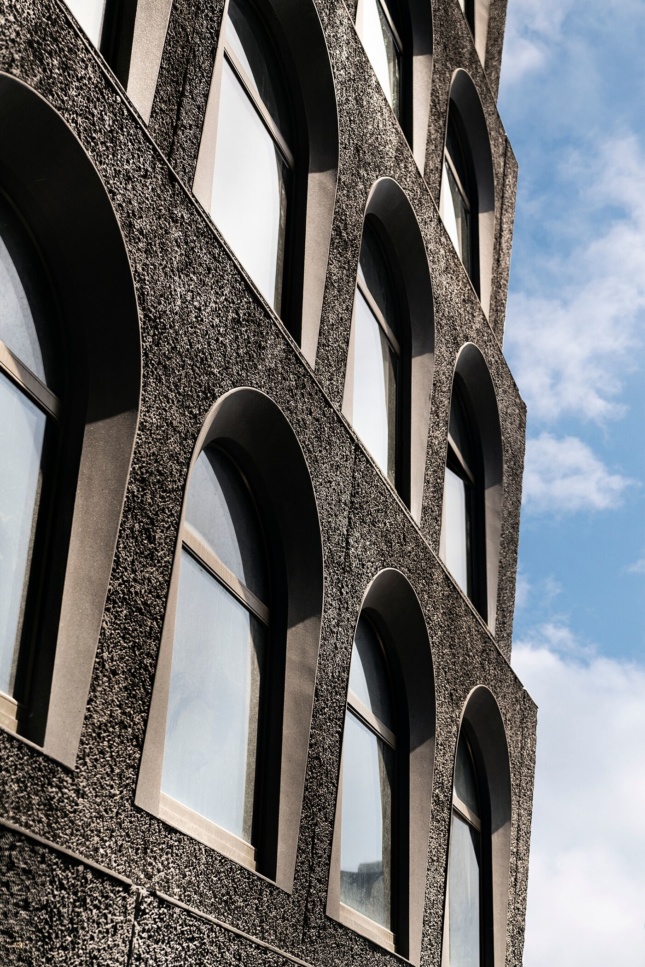 Photo of a pebbly, black arched facade