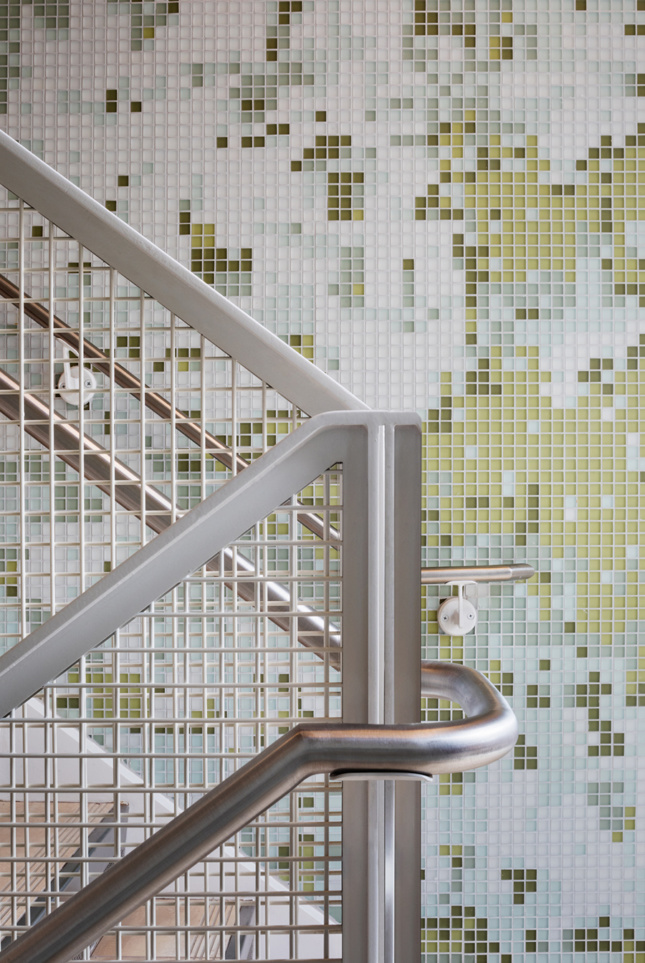 metal staircase banister and green tiled wall